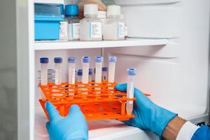 Young male scientist and laboratory freezer photo