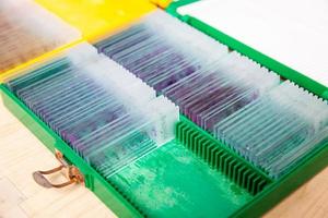 Box of stained tissue biopsy glass slides in pathology laboratory photo