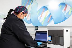 Female scientist working at the laboratory with a thermal cycler. Polymerase chain reaction technique. PCR technique photo