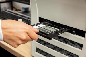 Scientist scanning microscope slides with tissue samples for pathology studies. Cancer diagnosis concept. Medical technology concept. photo