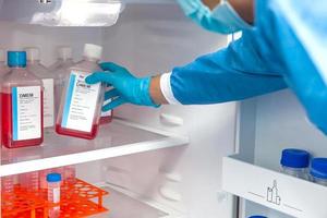 Young male scientist and laboratory refrigerator photo