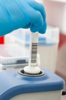 Scientist mixes a biological sample for analysis using a lab vortex mixer with adjustable stirring speed with touch. photo