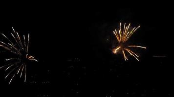 Festive beautiful fireworks in the night sky. Celebration events in the city. New Year and Christmas concept video