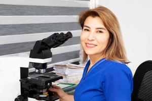 Pathologist working with stained tissue biopsy on glass slides in the laboratory photo