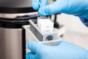 Scientist preparing slides with tissue samples for immunohistochemistry assay in the laboratory. Scientist at the Immunohistochemistry laboratory carry out antigen retrieval on biopsy tissue. photo