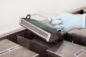 Scientist staining microscope slides for cytology studies in the laboratory. Fixation of samples through ethanol bathing. photo