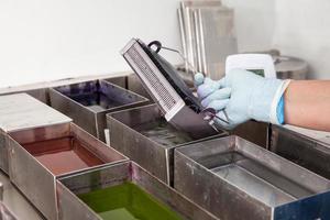 Scientist staining microscope slides for cytology studies in the laboratory. photo