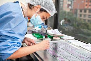 Young female scientist preparing slides with paraffin-embedded sections for pathological analysis. photo