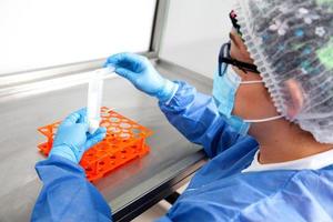 Young female scientist working in a safety laminar air flow cabinet at laboratory photo