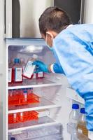 Young male scientist and laboratory refrigerator photo