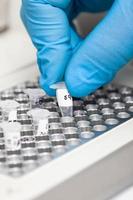 Closeup of a scientist hand while working at the laboratory with a thermal cycler. Polymerase chain reaction technique. PCR technique photo