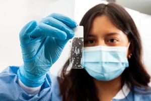 Young female scientist looking at a slide of dewaxed tissue samples in the laboratory. Xylene-based removal of paraffin. photo