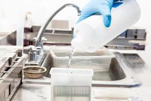Scientist dewaxing paraffin embedded tissue samples in the laboratory. Xylene-based removal of paraffin. photo