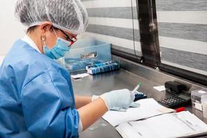 Laboratorian giving admission to pap smear samples in the laboratory for analysis. Scientist receiving patient samples for laboratory for analysis. Cervical cancer concept. Medical concept. photo