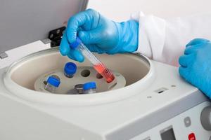 Scientist inserting a tube in a laboratory centrifuge photo