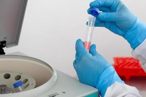 Scientist inserting a tube in a laboratory centrifuge photo