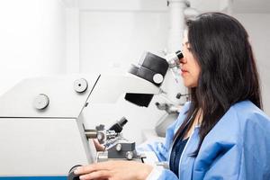 Young female scientist using an ultramicrotome to make sections for the electron microscope photo