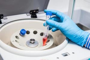 Scientist inserting a tube in a laboratory centrifuge photo