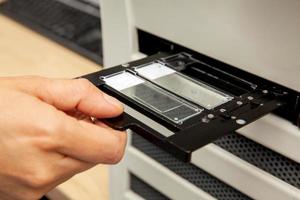 Scientist scanning microscope slides with tissue samples for pathology studies. Cancer diagnosis concept. Medical technology concept. photo