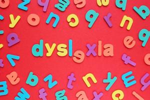 Color alphabet letters on red background. World Dyslexia Day concept. Solving the educational problem of reading. Medical and mental health awareness. Logopedy, psychology, learning lessons photo