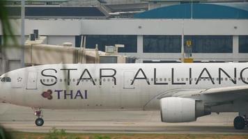 phuket, thailand 1. dezember 2016 - thai airways airbus a330 hs tel star alliance-lackierung rollt vor abflug. Blick von der obersten Etage des Hotels Centara Grand West Sands Resort Phuket video