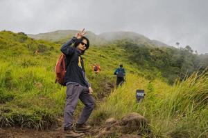 hombre excursionismo a el parte superior montaña, con savana pista y nublado vibras. el foto es adecuado a utilizar para aventuras contenido medios de comunicación, naturaleza póster y bosque antecedentes.