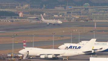 HONG KONG NOVEMBER 10, 2019 - DragonAir Airbus A330 B HYF turn runway before departure from Hong Kong, airfreighters Boeing 747 foreground video