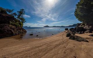 Tropical beach with rocks in West Sumatra coast, Indonesia photo