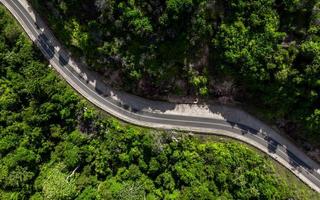 Aerial view of empty winding road in a forest. Highway through woodland photo