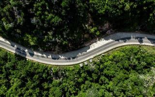 Aerial view of empty winding road in a forest. Highway through woodland photo