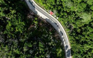 Aerial view of empty winding road in a forest. Highway through woodland photo