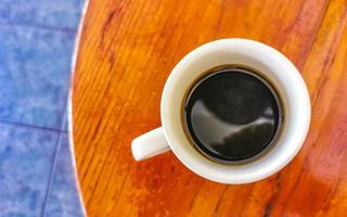 Blue white cup pot with black coffee wooden table Mexico. photo