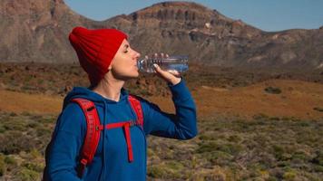 escursioni a piedi donna potabile acqua dopo escursione su teide, tenerife. caucasico femmina turista su tenerife, canarino isole video