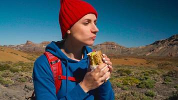 excursionismo mujer comiendo emparedado después caminata en teide, tenerife caucásico hembra turista en tenerife, canario islas video