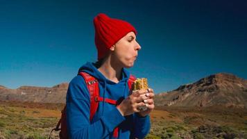 Hiking woman eating sandwich after hike on Teide, Tenerife. Caucasian female tourist on Tenerife, Canary Islands video