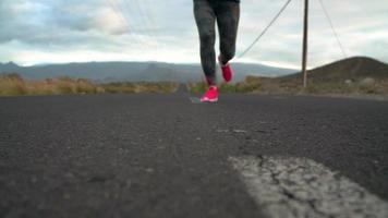 Running shoes - woman tying shoe laces on a desert road in a mountainous area video