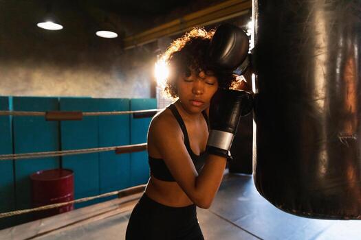 mujer yo defensa niña fuerza. africano americano mujer combatiente descansando después lucha formación en boxeo anillo. niña cansado después puñetazos boxeo bolsa. formación día en gimnasia, fuerza ajuste cuerpo rutina de ejercicio formación foto