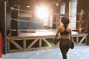 mujer yo defensa. africano mujer combatiente preparando para competencia lucha yendo a boxeo anillo. fuerte niña Listo para lucha activo ejercicio combate rutina de ejercicio capacitación. formación día en boxeo gimnasia. foto