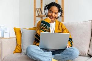 africano americano niña utilizando ordenador portátil a hogar oficina mirando a pantalla mecanografía chateando leyendo escritura correo electrónico. joven mujer teniendo virtual reunión en línea charla vídeo llamada conferencia trabajo aprendizaje desde hogar foto