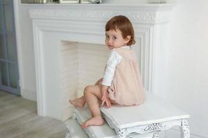 Little girl sitting on modern chair photo