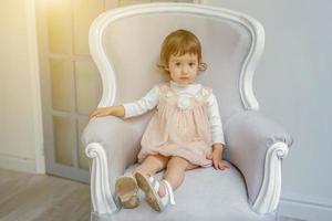 pequeño niña sentado en moderno silla foto