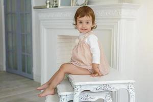 Little girl sitting on modern chair photo