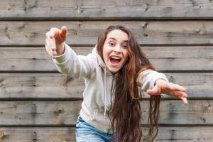 Happy girl smiling. Beauty portrait young happy positive laughing brunette woman on wooden wall background photo