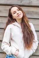 Happy girl smiling. Beauty portrait young happy positive laughing brunette woman on wooden wall background photo