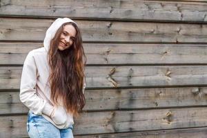 Happy girl smiling. Beauty portrait young happy positive laughing brunette woman on wooden wall background photo