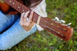 Woman hands playing acoustic guitar photo