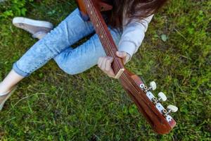 Woman hands playing acoustic guitar photo