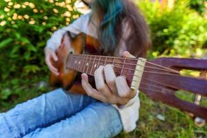 manos de mujer tocando la guitarra acustica foto