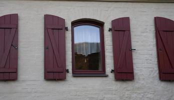 antiguo Clásico ventana con de madera persianas y un cortina foto