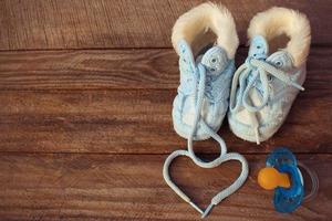 heart symbol is drawn laces of children's shoes and a pacifier photo